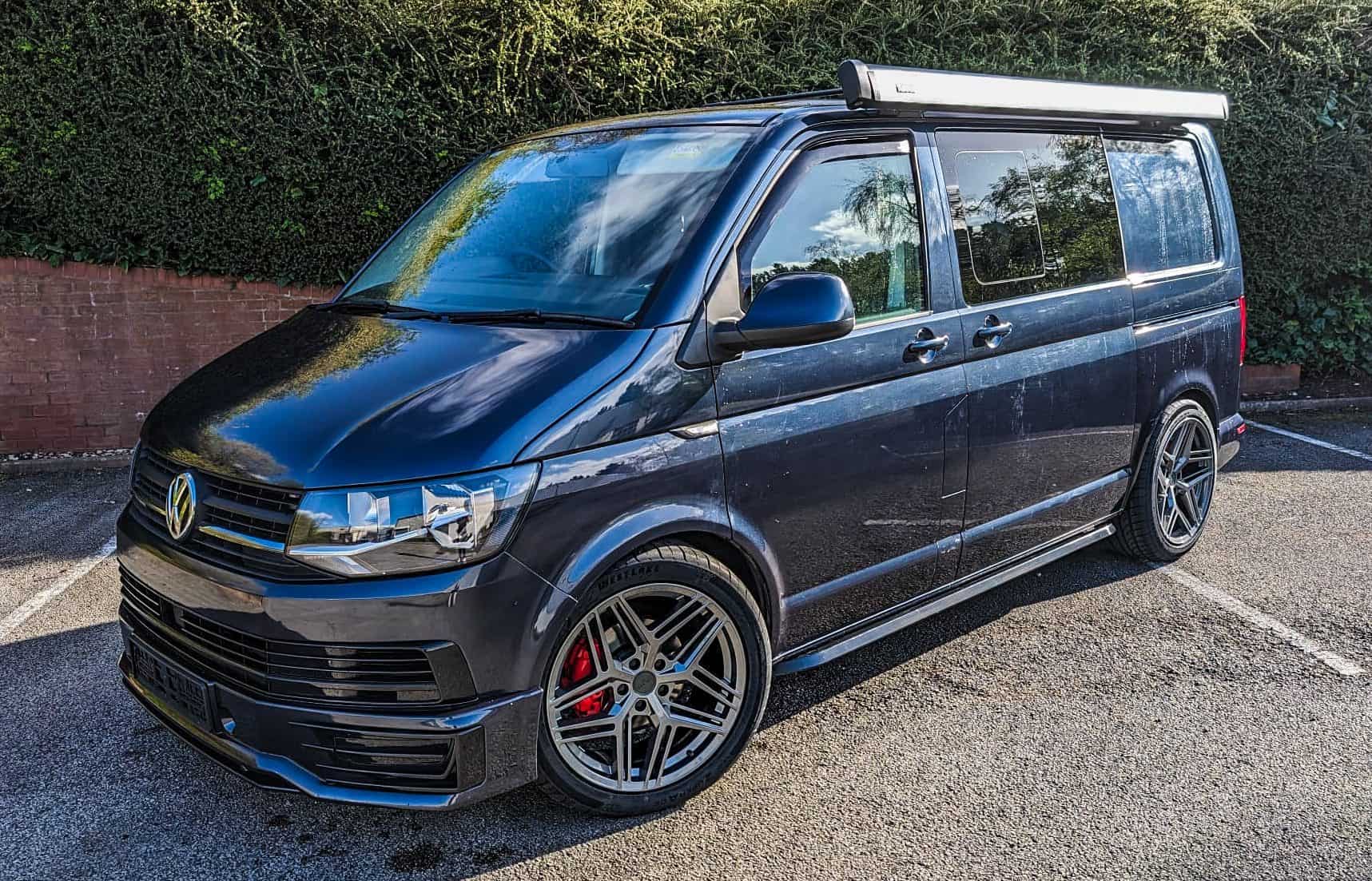 Custom-wrapped Volkswagen T6 van with tinted windows and alloy wheels.