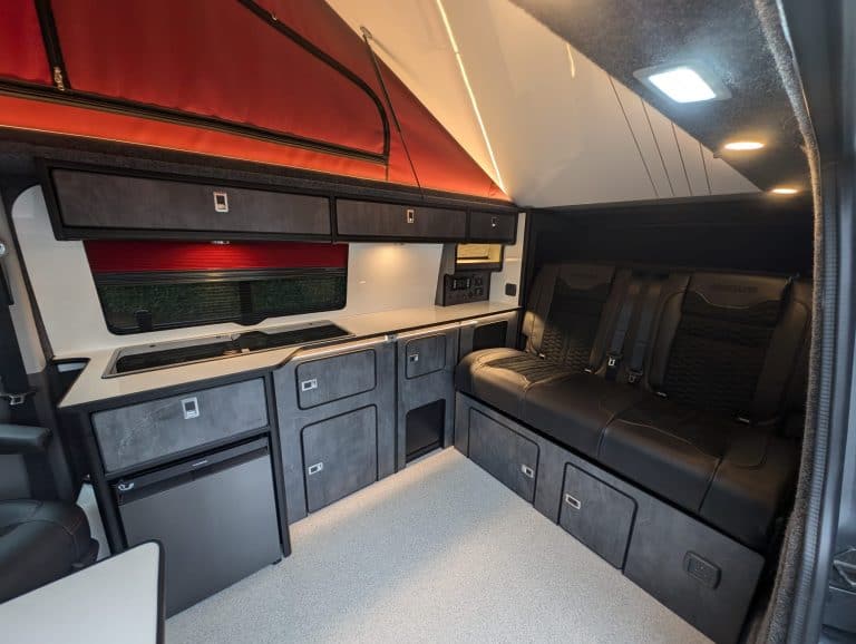 Modern camper van interior with custom cabinetry and seating for travel comfort.