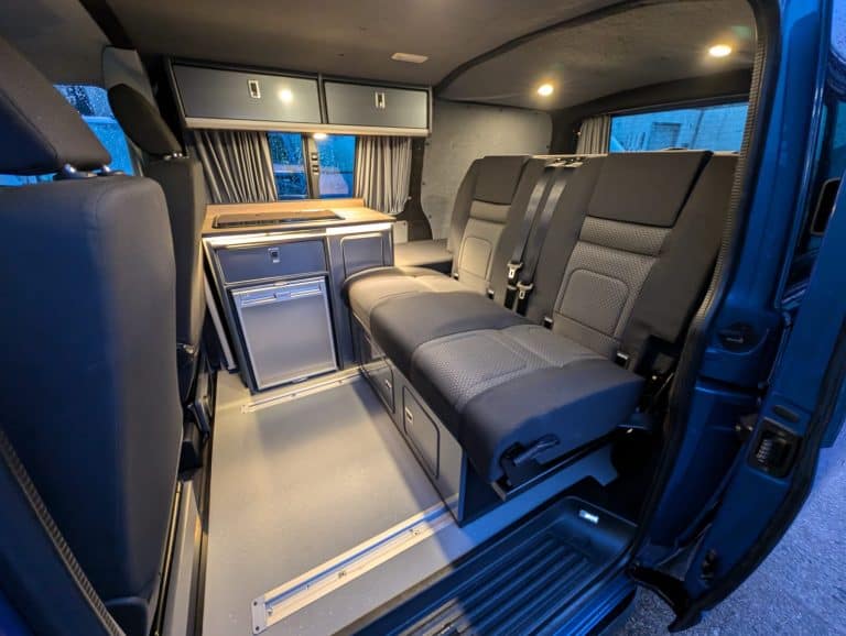 Van interior conversion with seating and storage solutions for transport.