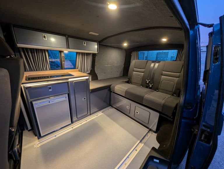 Interior van conversion with seating, storage, and workspace solutions for mobile living or work pur.